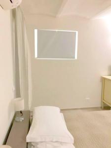 a white room with a bed and a window at Scalette Via Elia in Numana