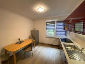 una pequeña cocina con mesa de madera y fregadero en Pension Florion, en Bernburg
