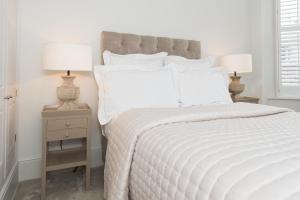 a bedroom with a white bed with two lamps on night stands at Harrogate Serviced Apartments in Harrogate