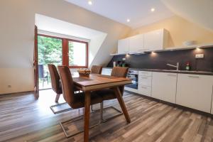 a kitchen with a wooden table and chairs in a room at Ferienwohnung Bad Bertrich in Bad Bertrich