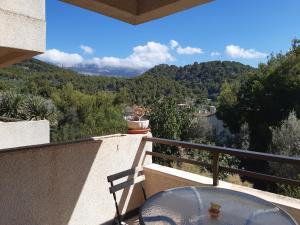 einen Balkon mit einem Tisch und Bergblick in der Unterkunft Moderno apartamento con vista a la montaña in Port de Sóller