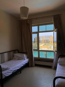 a bedroom with a bed and a large window at شقة مارينا البيلسان - عائلات فقط in King Abdullah Economic City