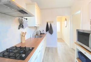 a kitchen with a stove top oven next to a sink at Who's Anton for you or two, Monnickendam near Amsterdam in Monnickendam