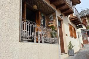 einem Hund, der auf einem Balkon eines Gebäudes sitzt in der Unterkunft Agiaz' in Arachova