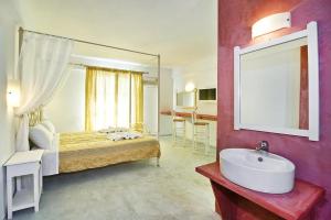 a hotel room with a bath tub, sink, and mirror at Sea View Beach Hotel in Perivolos