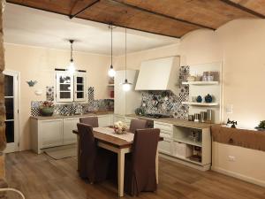 - une cuisine avec une table et des chaises dans la chambre dans l'établissement Il Leccio - casa toscana il fienile, à Gambassi Terme