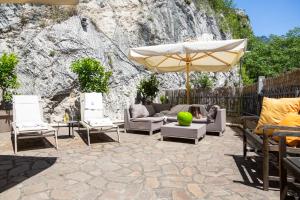 a patio with chairs and an umbrella at Villa Fiore in Nago-Torbole