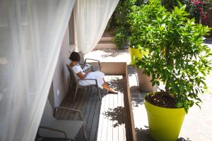 kobieta siedząca na krześle na balkonie w obiekcie Villa Fiore w orbole