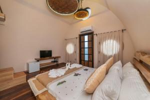 a bedroom with a large bed and a tv at İksirci Baba Hotel in Oludeniz