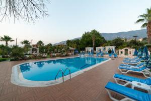 a swimming pool with blue lounge chairs and a resort at İksirci Baba Hotel in Oludeniz
