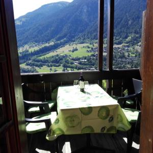 a table and chairs with a view of a valley at Chalet-Schümli Maisonette in Ernen