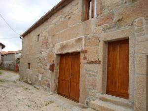 een stenen gebouw met twee houten deuren erop bij Casa Da Laborada in Vilar de Perdizes