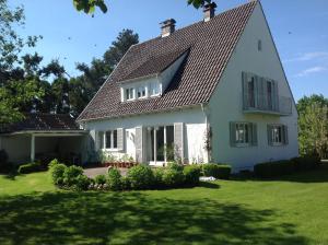 een wit huis met een gambrel dak bij Haus Hirt - Idyllisch wohnen zwischen Augsburg und München in Klosterlechfeld