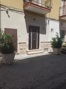 een gebouw met twee potplanten voor een deur bij PERFETTA LETIZIA in Bitonto