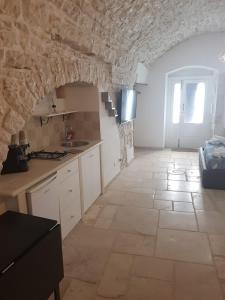 een grote keuken met een stenen muur en een vloer bij PERFETTA LETIZIA in Bitonto