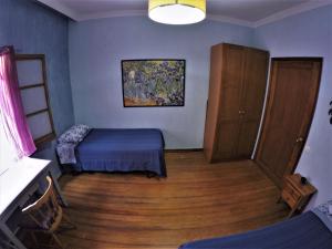 a bedroom with a bed and a wooden floor at A Casa Mia in Las Palmas de Gran Canaria