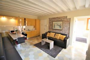 a living room with a black couch and a kitchen at New central and spacious in Venice