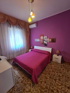 a purple bedroom with a large bed with purple walls at Lorena Loft in Locri