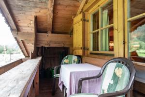 una mesa y sillas en el porche trasero de una cabaña en Gasthaus Häusling Alm, en Mayrhofen