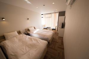 Habitación de hotel con 2 camas y mesa en City Kaigetsu en Sumoto
