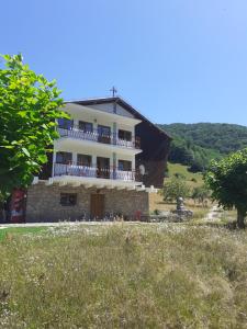 a large house with a balcony on a hill at Pensiunea Costesti in Costeşti