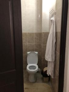 a bathroom with a toilet and a towel on the wall at Keruen in Taraz