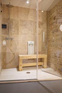 La salle de bains est pourvue d'une douche, d'une table en bois et d'une cabine de douche. dans l'établissement OGNISSANTI GuestHouse & Suites, à Fermo