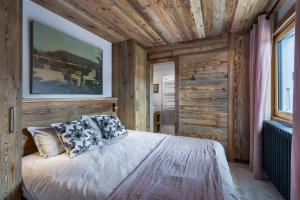 um quarto com paredes de madeira e uma cama com almofadas em MEGEVE Jaillet 3 chambres 6 personnes em Megève