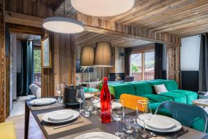 uma sala de jantar com um sofá verde em MEGEVE Jaillet 3 chambres 6 personnes em Megève