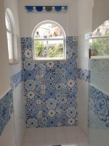 un bagno con piastrelle bianche e blu e una finestra di Regina Margherita a Positano