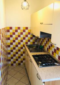 a kitchen with a stove and a checkered wall at Appartamenti Venere in San Vincenzo