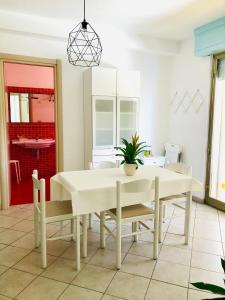 comedor con mesa blanca y sillas en Appartamenti Venere, en San Vincenzo