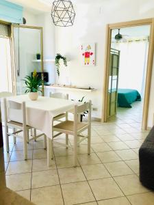 comedor con mesa blanca y sillas en Appartamenti Venere, en San Vincenzo