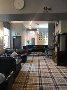 a living room with couches and a tv in it at The Station Hotel in Worksop