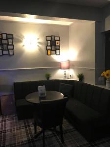 a living room with a couch, coffee table and a lamp at The Station Hotel in Worksop