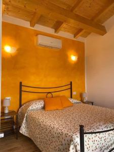 a bedroom with a bed and a yellow wall at Il Melarancio in Pescia Romana +110 photos