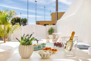 a table with a bottle of wine and a bowl of fruit at La Giada by Perle di Puglia in Maruggio