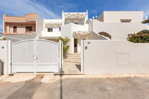 a white fence in front of a white house at La Giada by Perle di Puglia in Maruggio