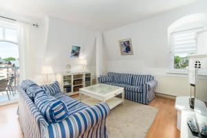 - un salon avec deux canapés rayés bleus et une table dans l'établissement Hotel Marina, à Międzyzdroje