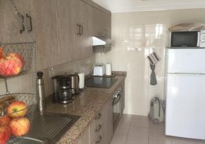 a kitchen with a white refrigerator and a sink at Apartamento Sol y Mar in Tazacorte