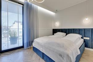 a bedroom with a large bed and a large window at Grand Apartments - Indygo Okrzei Residence Sopot in Sopot