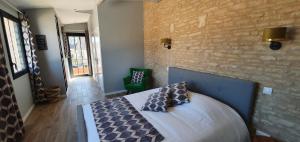 1 dormitorio con cama y pared de ladrillo en Les 5 rûches en Courseulles-sur-Mer