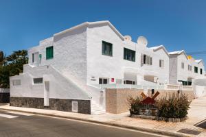 a white building on the side of a street at Apartamento Victoria in Puerto del Carmen