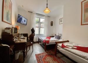 a room with two beds and a desk and a window at Hotelik Gdanska in Oberhausen