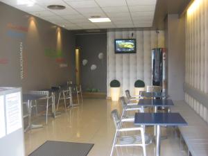 un ristorante con tavoli e sedie e una TV a parete di albergue SANTO SANTIAGO a Santiago de Compostela
