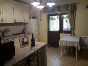 eine Küche mit weißen Schränken, einem Tisch und einem Fenster in der Unterkunft Casa VIP in Bacău
