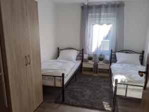een slaapkamer met 2 bedden en een raam bij Ferienwohnung Zundel in Neu-Anspach