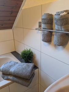 ein Bad mit Waschbecken und Handtüchern an der Wand in der Unterkunft Ferienwohnung Zundel in Neu-Anspach