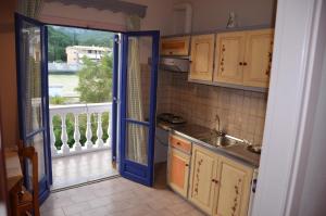 een keuken met een blauwe deur en een wastafel bij Antigoni Apartments in Parga