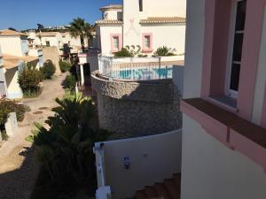 a view from a balcony of a house with a swimming pool at Modern Two Bedroom Poolside Townhouse in Budens